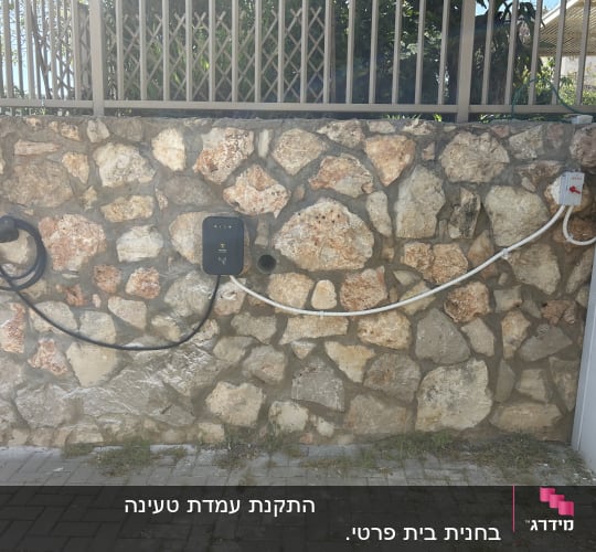 עמדת טעינה לרכב חשמלי על קיר אבן